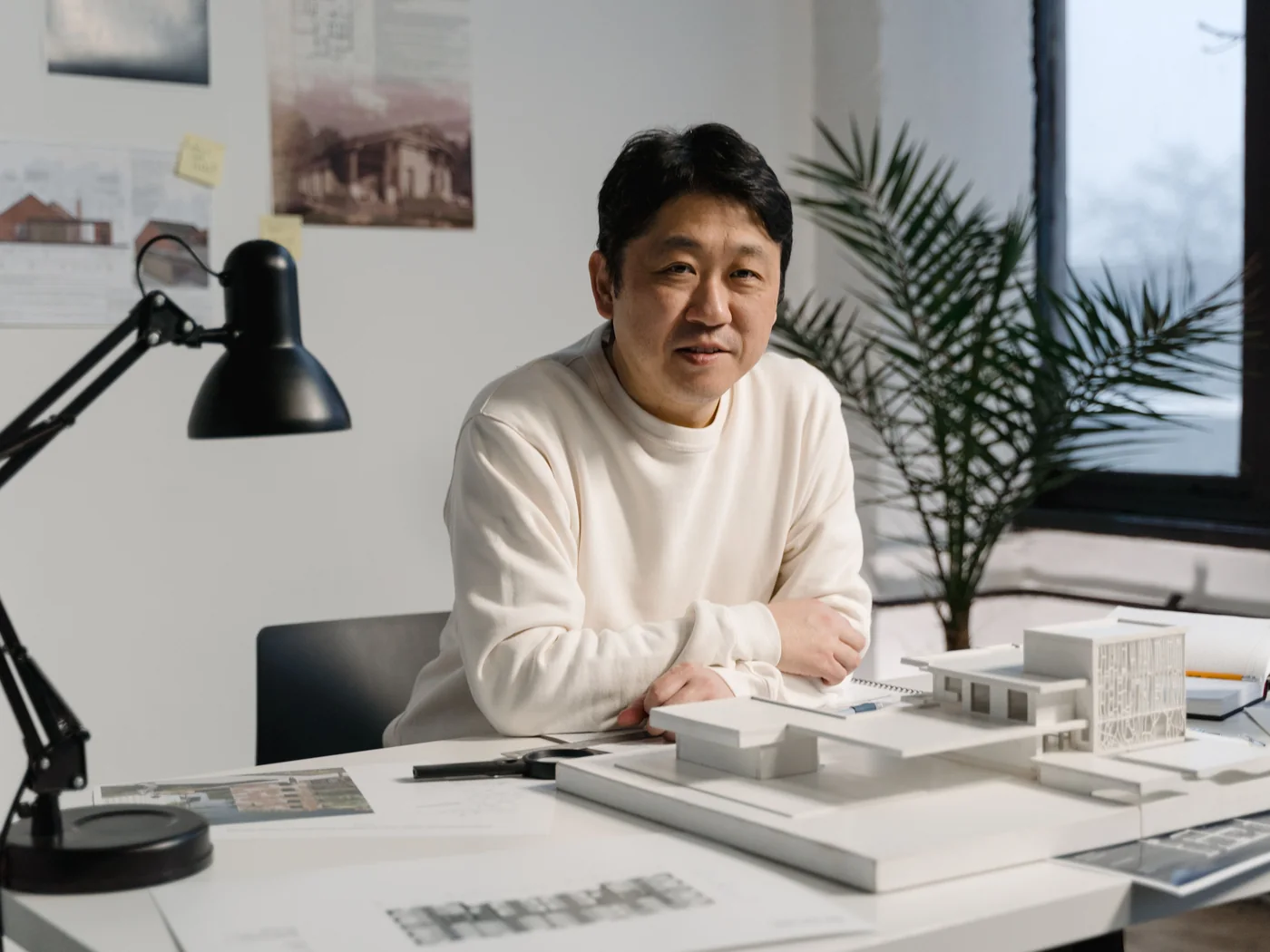 Arquiteto trabalhando com maquetes e plantas em um estúdio.