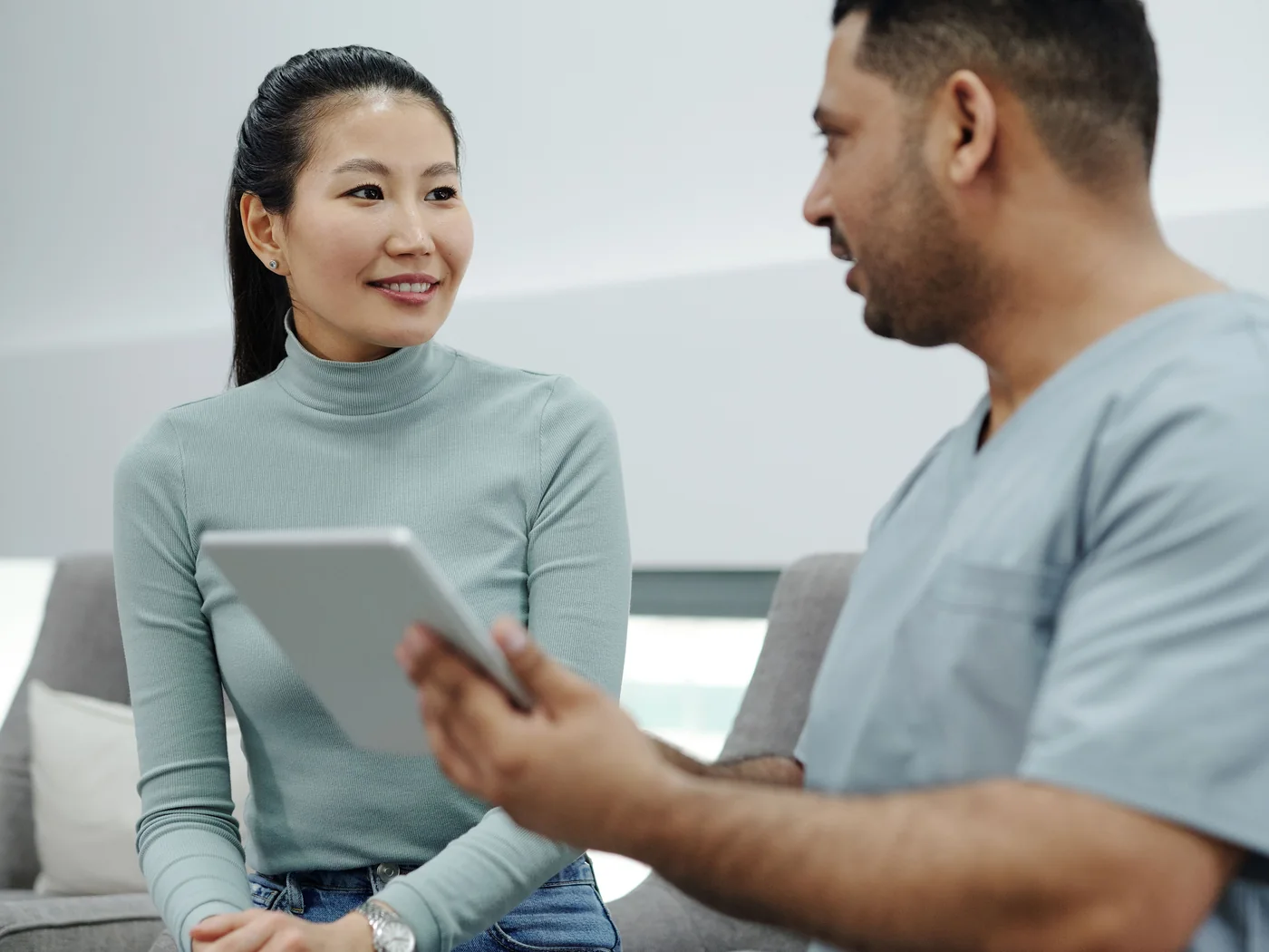 Profissional de saúde conversando com uma paciente durante consulta.