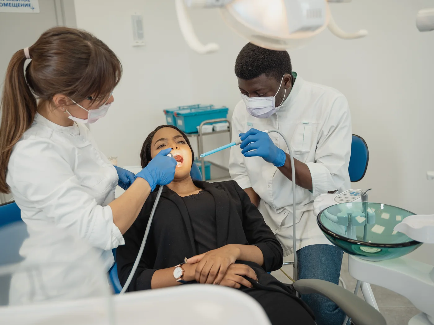 Dentistas realizando atendimento em uma clínica odontológica moderna.